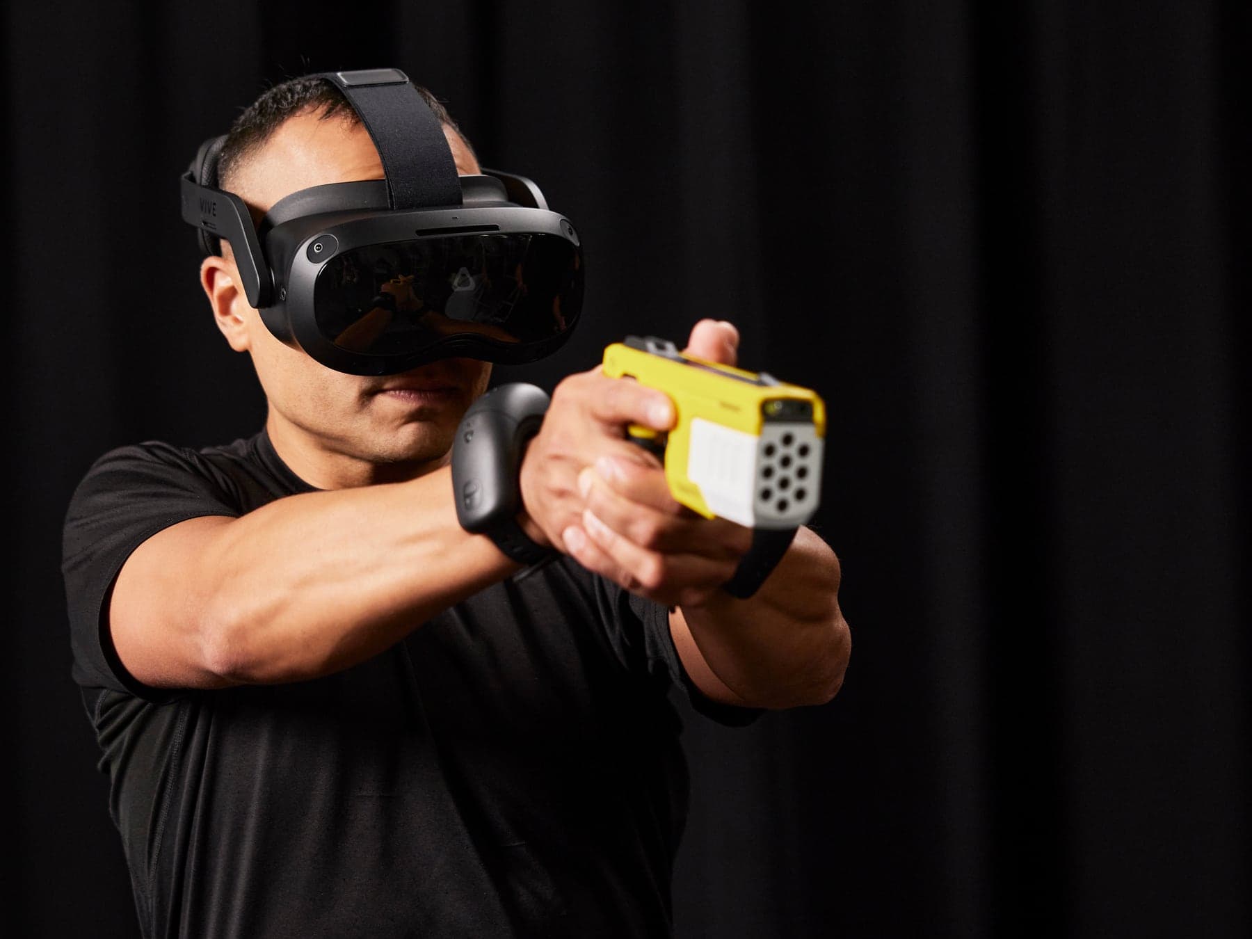 Training with the Axon VR training system: a trainee in a virtual reality headset points the TASER 10 VR training controller into a virtual scenario